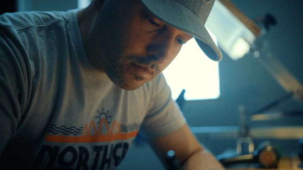 Jeremy Symons, Founder and Creative Director of Yooper Shirts, working on apparel and brand design at the company's creative headquarters in Ishpeming, Michigan.